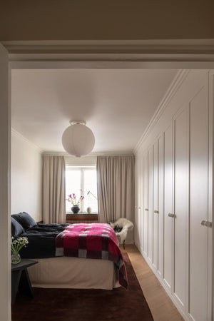 Layered Solid Wool Chicory Coffee donkerbruin wollen vloerkleed, in een slaapkamer