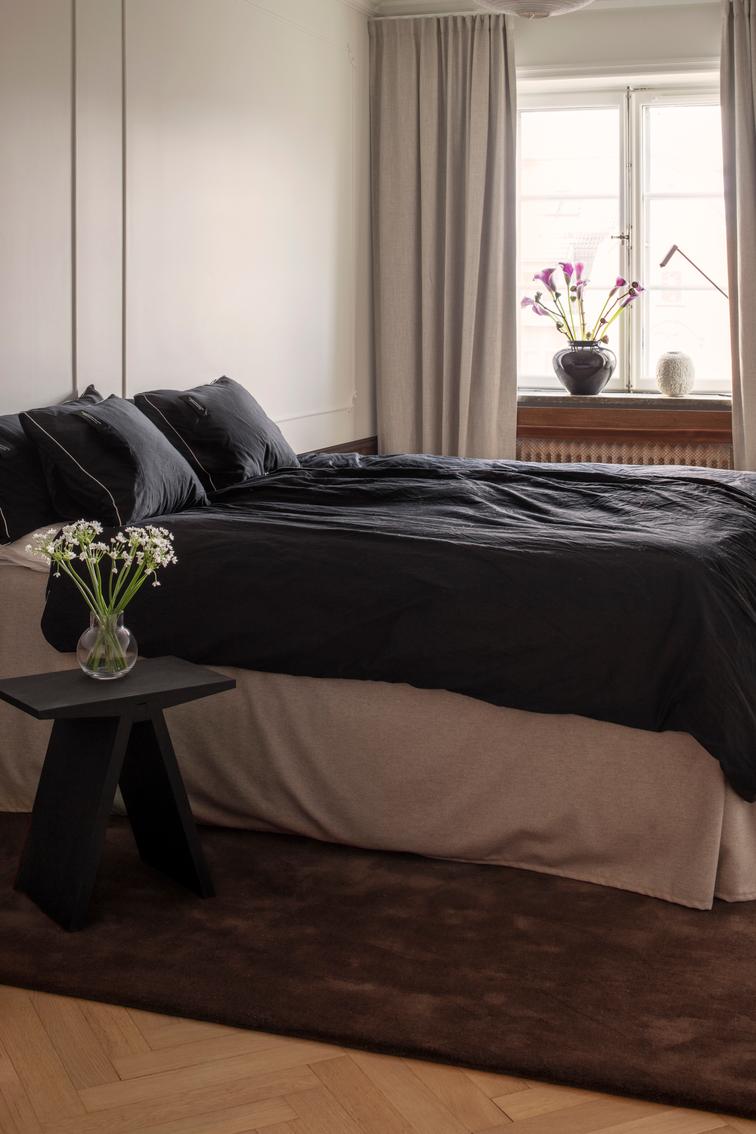 Layered Solid Wool Chicory Coffee donkerbruin wollen vloerkleed, in een slaapkamer