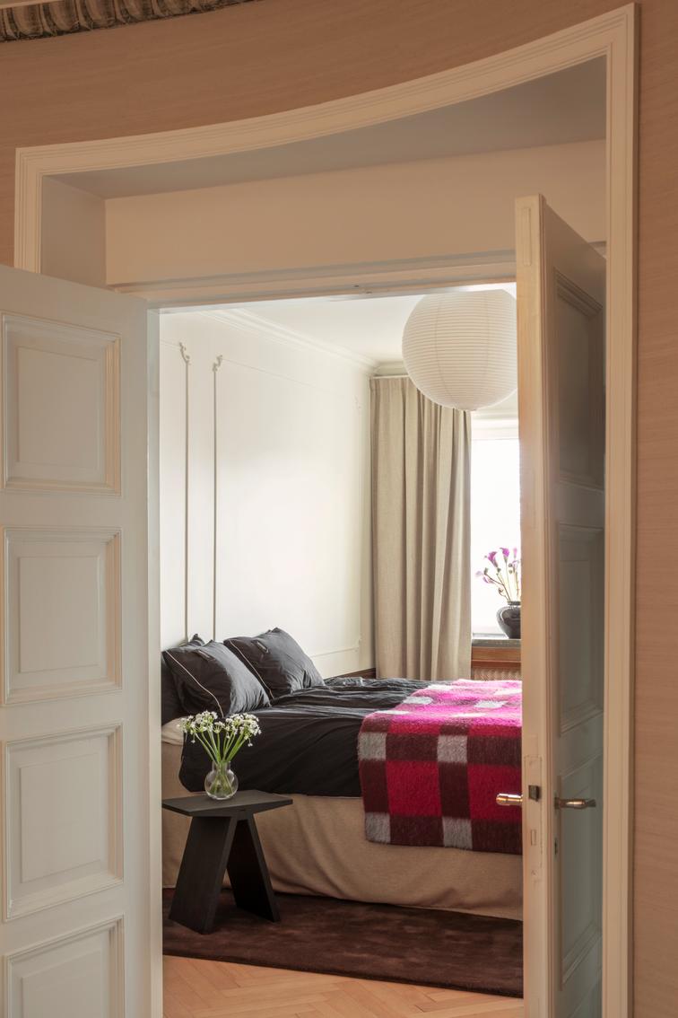 Layered Solid Wool Chicory Coffee donkerbruin wollen vloerkleed, in een slaapkamer