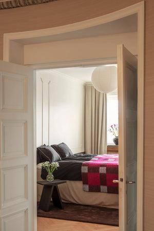Layered Solid Wool Chicory Coffee donkerbruin wollen vloerkleed, in een slaapkamer