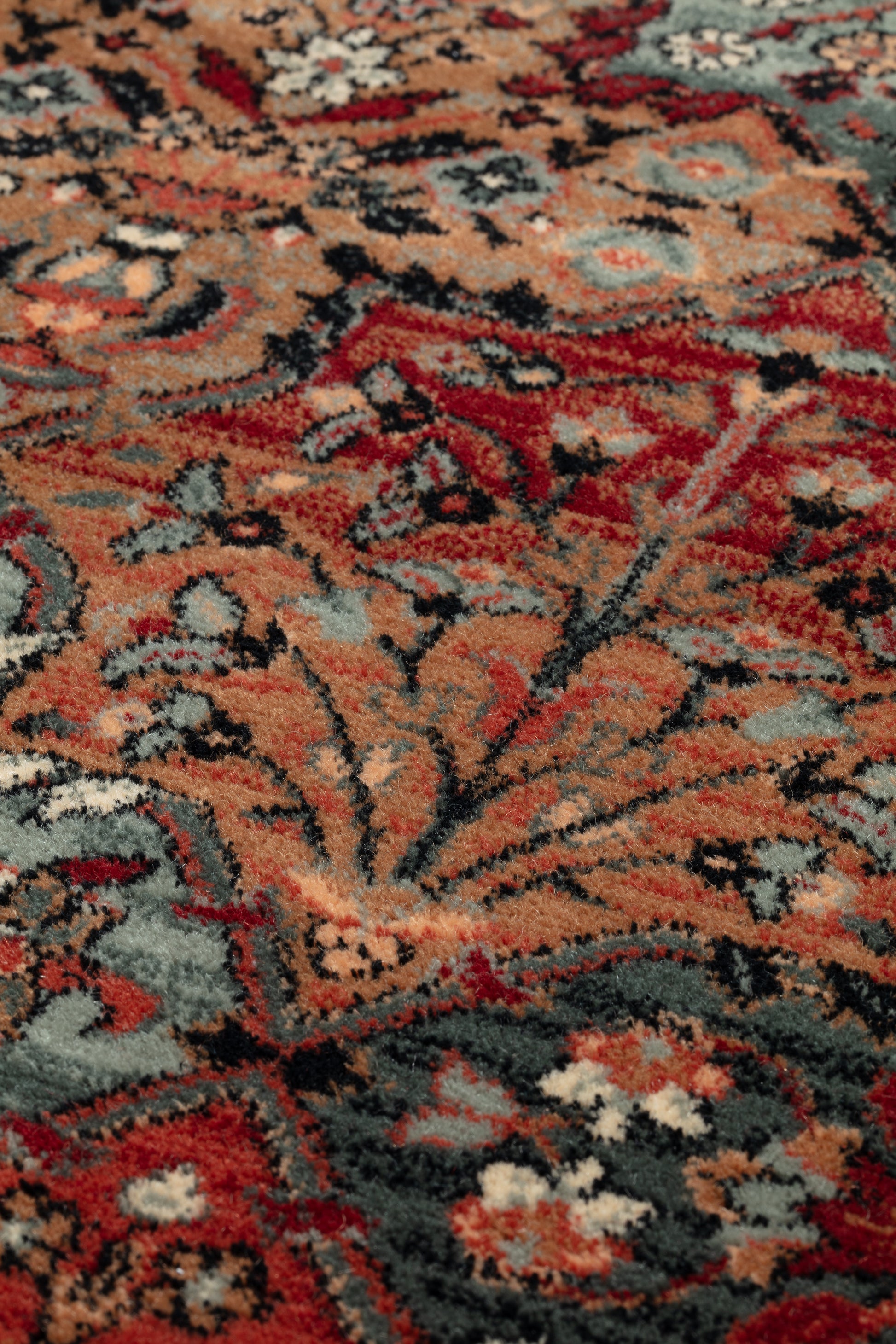 Close-up of a patterned rug with red, orange, and blue colors.
