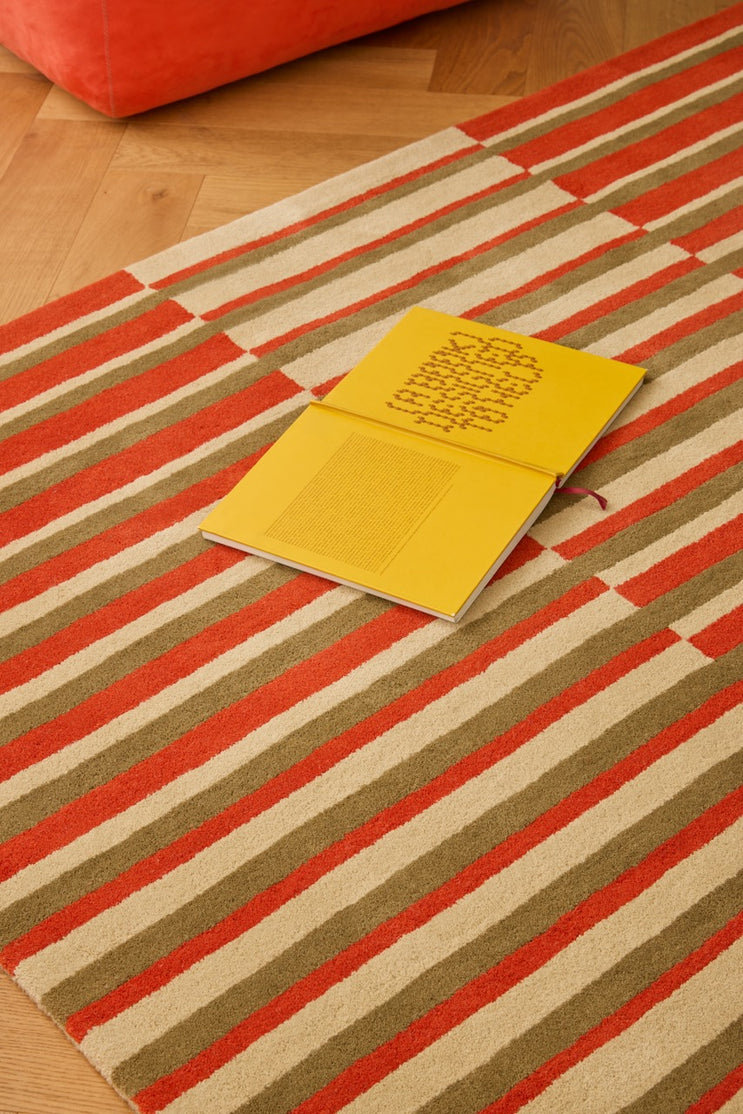 Brink & Campman Decor Pilar Coral tapijt in koraalrood met strepen in olijfgroen en crème, in een interieur, tweede beeld