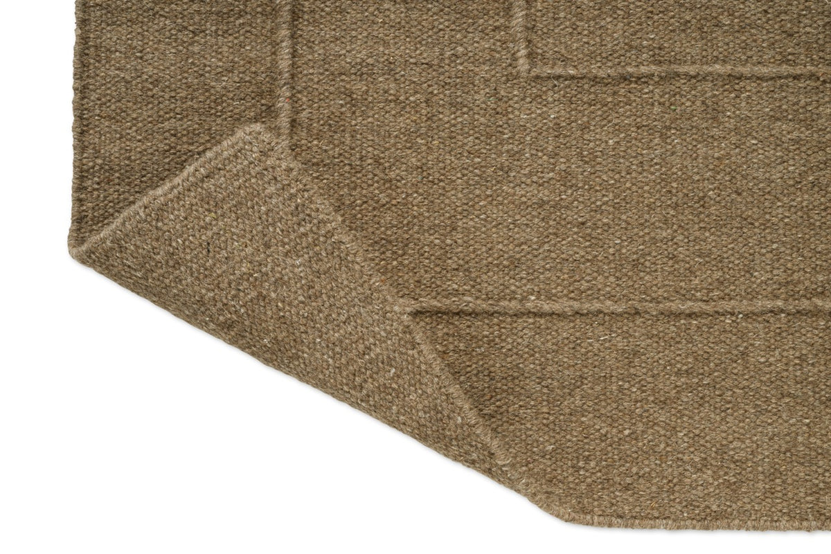 Brink & Campman Senso Border Fur Brown tapijt, detail van omgeslagen hoek en achterzijde