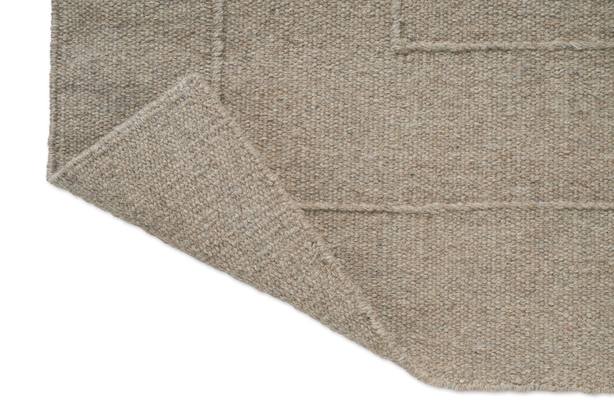 Brink & Campman Senso Border Soft Taupe tapijt, detail van omgeslagen hoek en achterzijde
