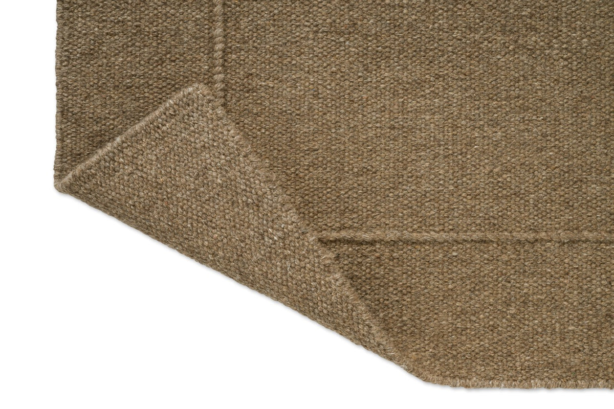 Brink & Campman Senso Planes Fur Brown tapijt, detail van omgeslagen hoek en achterzijde