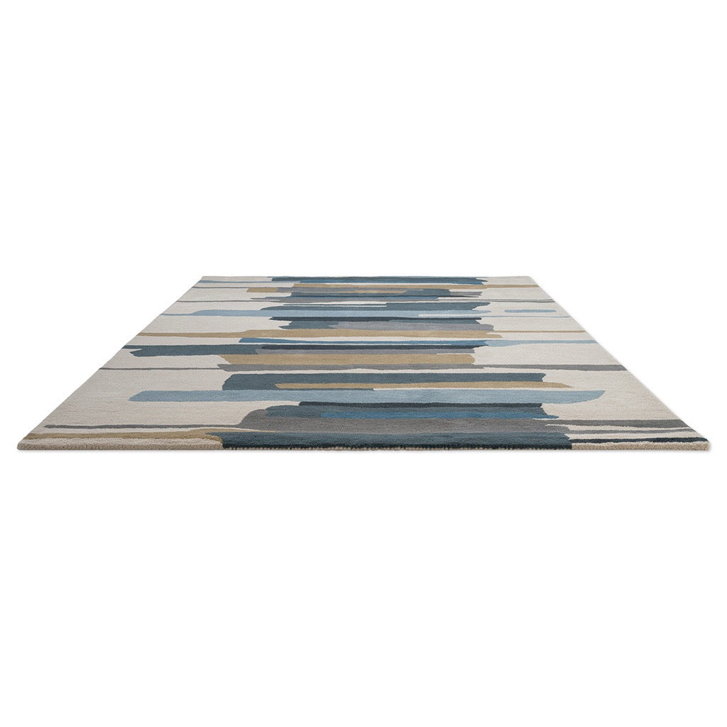 Tapis Harlequin Zeal Indigo ivoire aux coups de pinceau bleus et ocre, vue en perspective