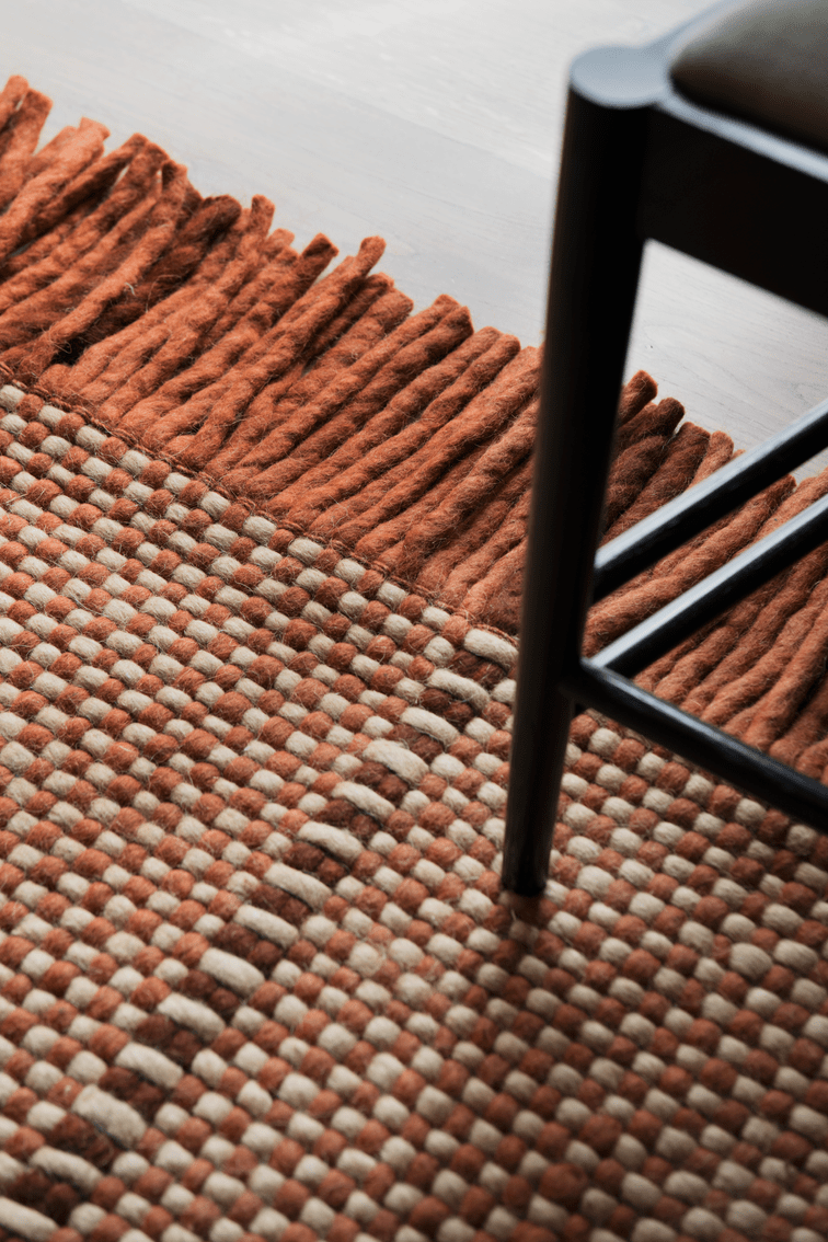 Layered x Massproductions Cord Burgundy Rust gestreifter Wollteppich, Detail von Gewebe und Fransen