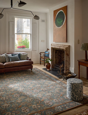 Morris & Co Theodosia Bottle Green rug in bottle green with caramel and ivory flowers, shown in an interior