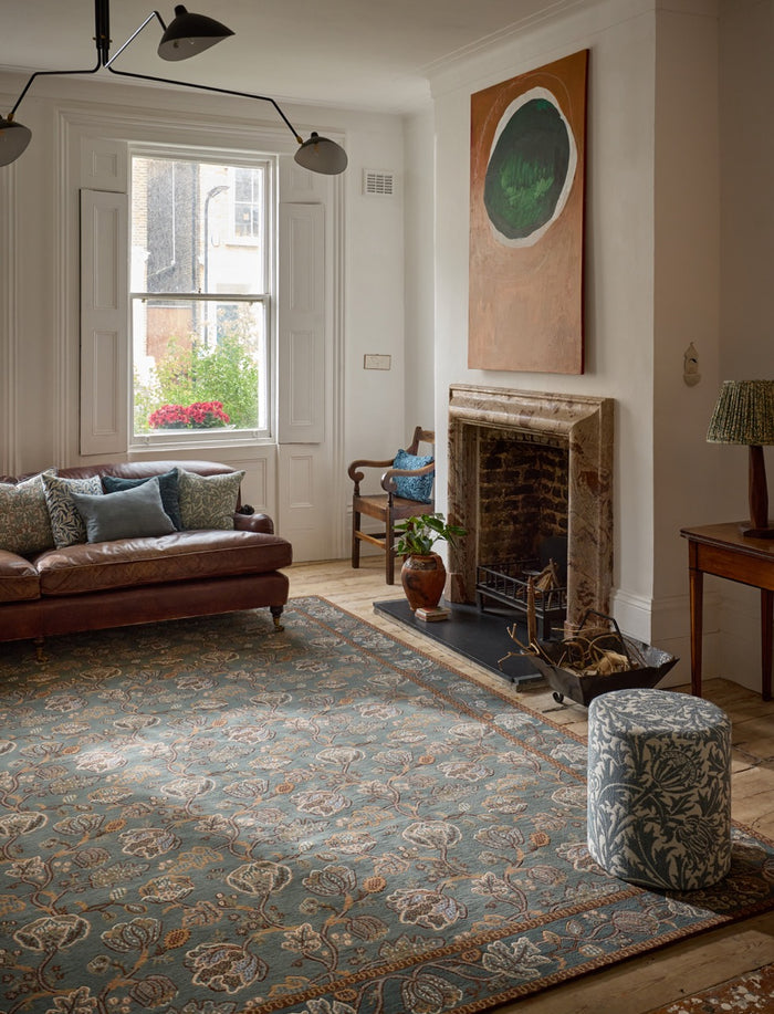 Morris & Co Theodosia Bottle Green rug in bottle green with caramel and ivory flowers, shown in an interior