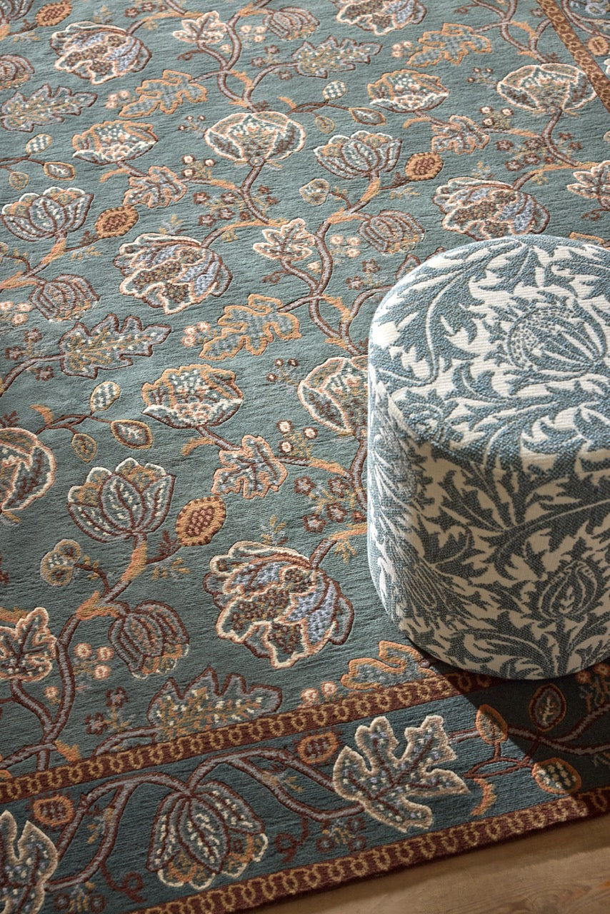 Morris & Co Theodosia Bottle Green rug in bottle green with caramel and ivory flowers, shown in an interior, second view