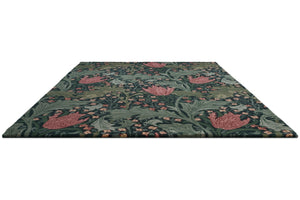 Morris & Co Lent Lily Indigo Madder rug in indigo with madder red tulips and sage leaves, perspective view
