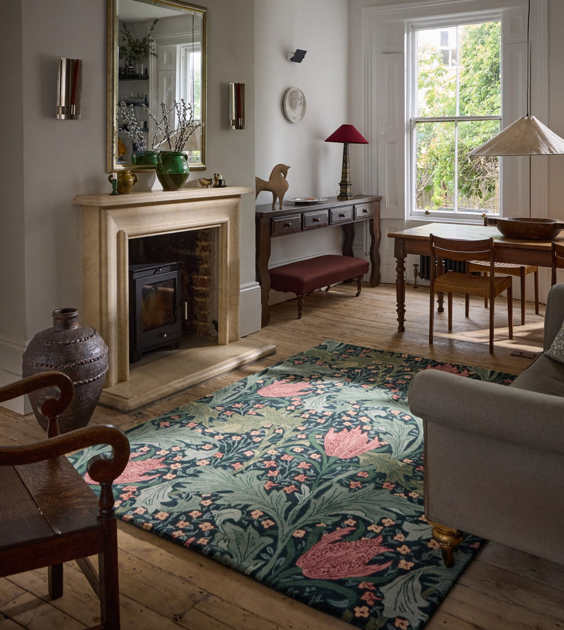 Morris & Co Lent Lily Indigo Madder rug in indigo with madder red tulips and sage leaves, shown in an interior