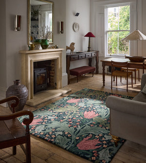 Morris & Co Lent Lily Indigo Madder rug in indigo with madder red tulips and sage leaves, shown in an interior