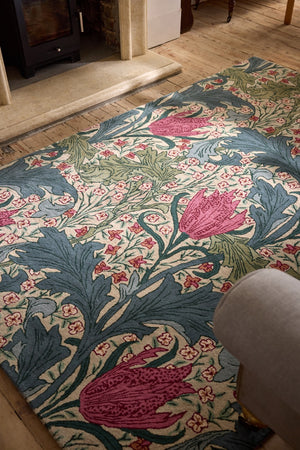 Morris & Co Lent Lily Plum Bayleaf rug in cream with plum tulips and bay green leaves, shown in an interior, second view