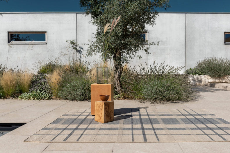 Exterior lounge featuring Zona Check Denim rug with modern seating on tiled patio